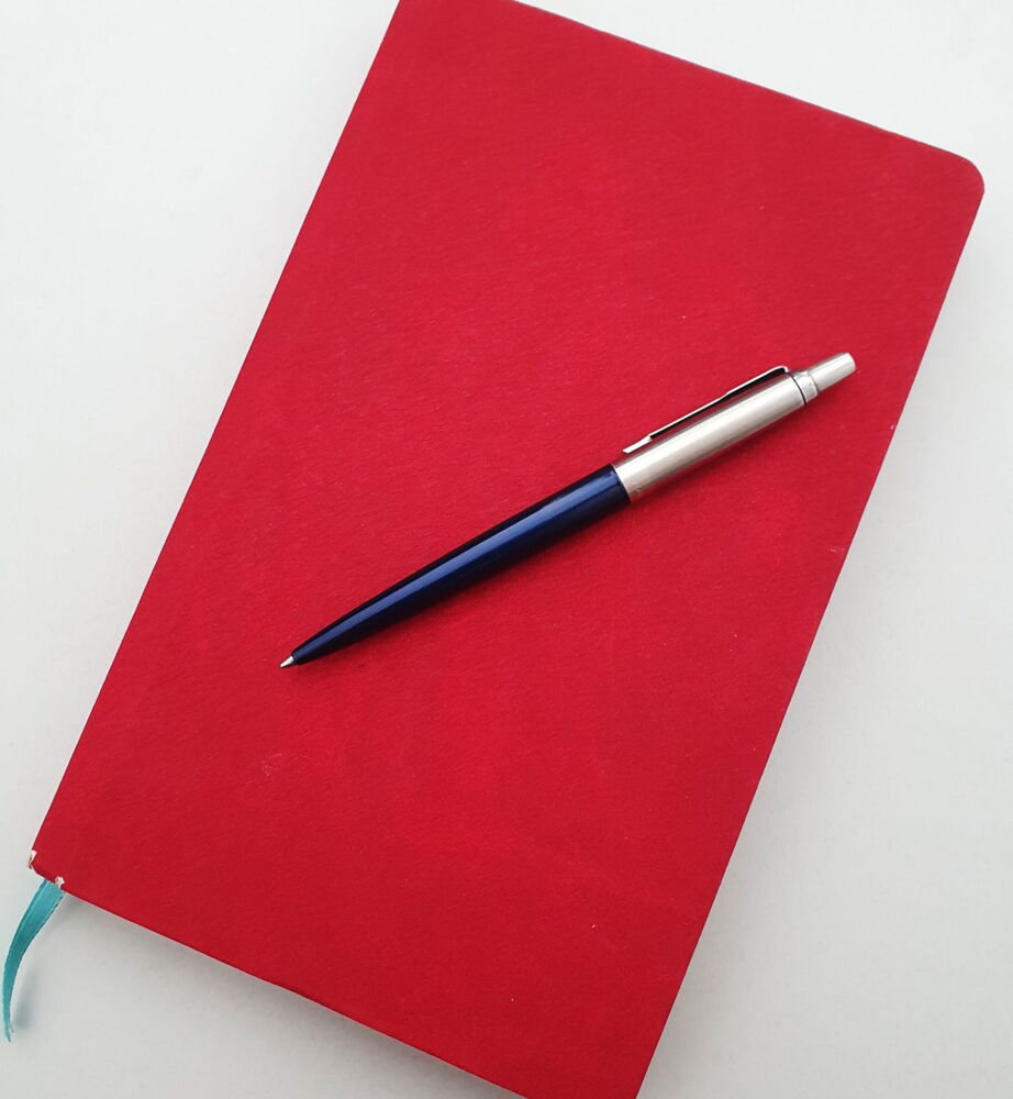 roter Kalender mit blauem Kugelschreiber