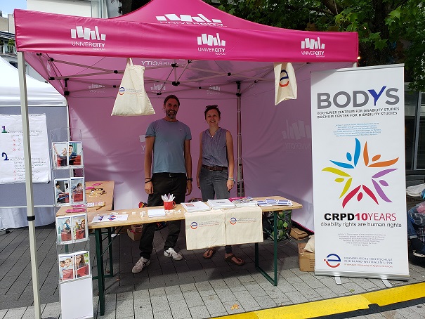 EvH-Info-Stand mit Dr. Stefan Schache von BODYS und EvH-Kollegin Kristin Wallmeyer. Vorn rechts steht ein Aufsteller mit der Schrift 