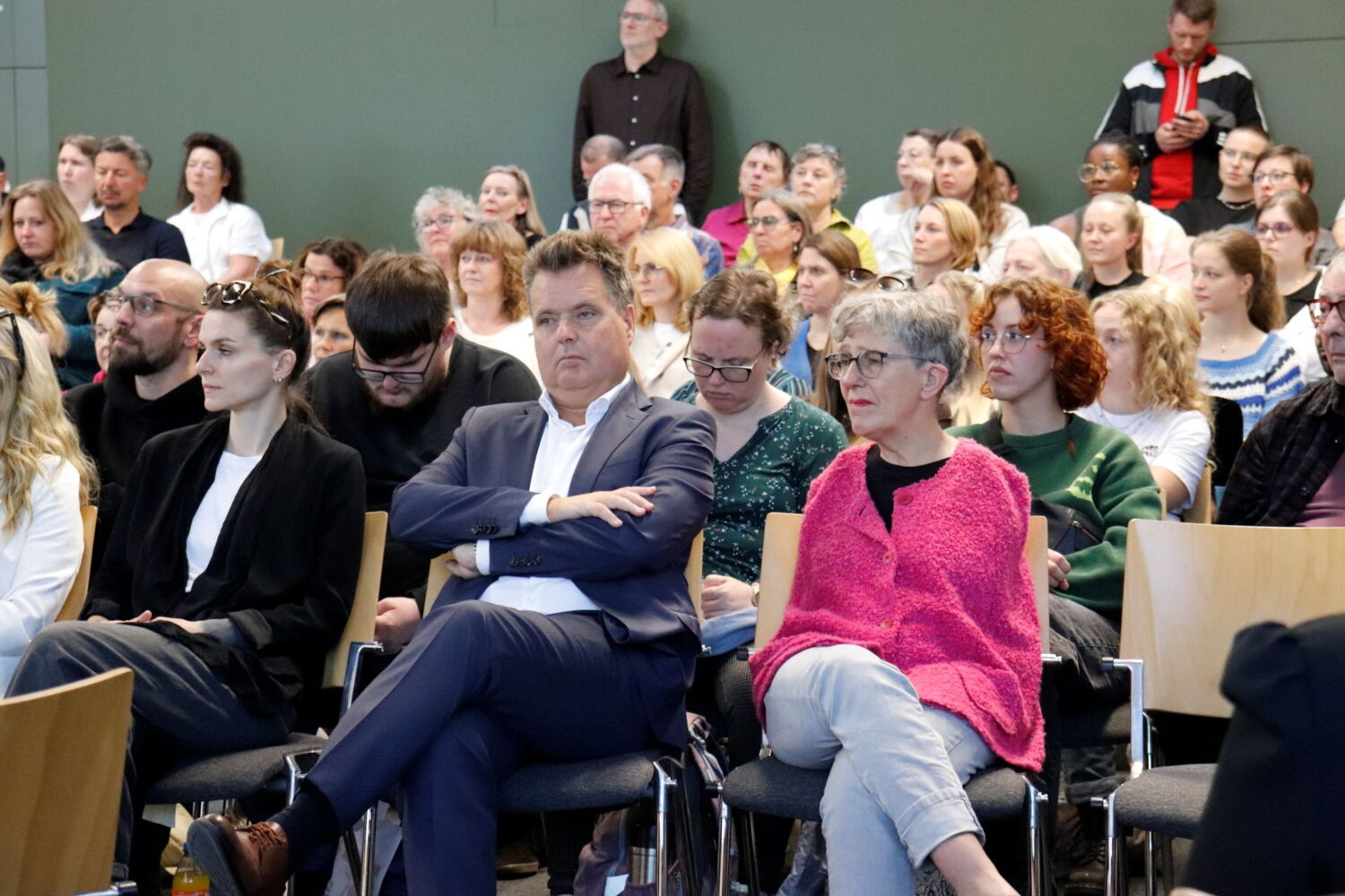 Blick in einen vollen Saal, im Vordergrund sitzen Jürgen Dusel und Theresia Degener.